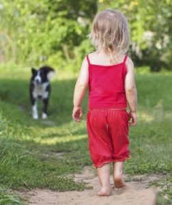 photo of little child and dog in park